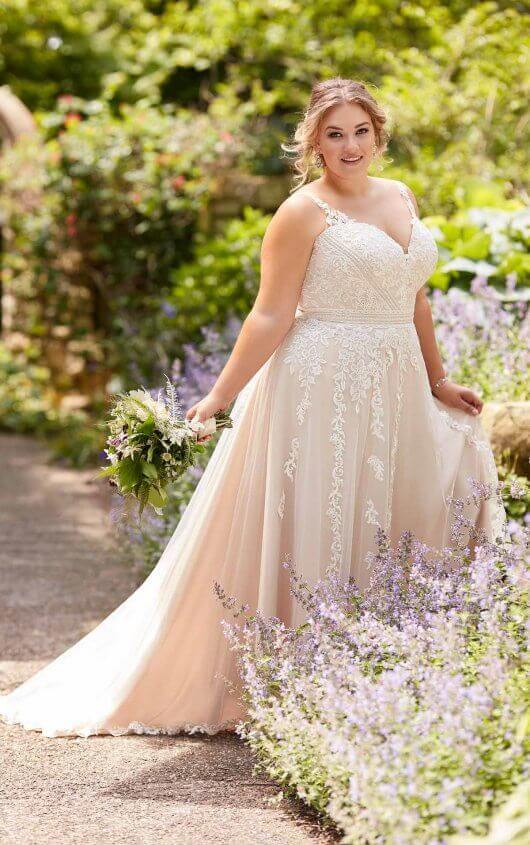A woman in a wedding dress standing in a flower garden