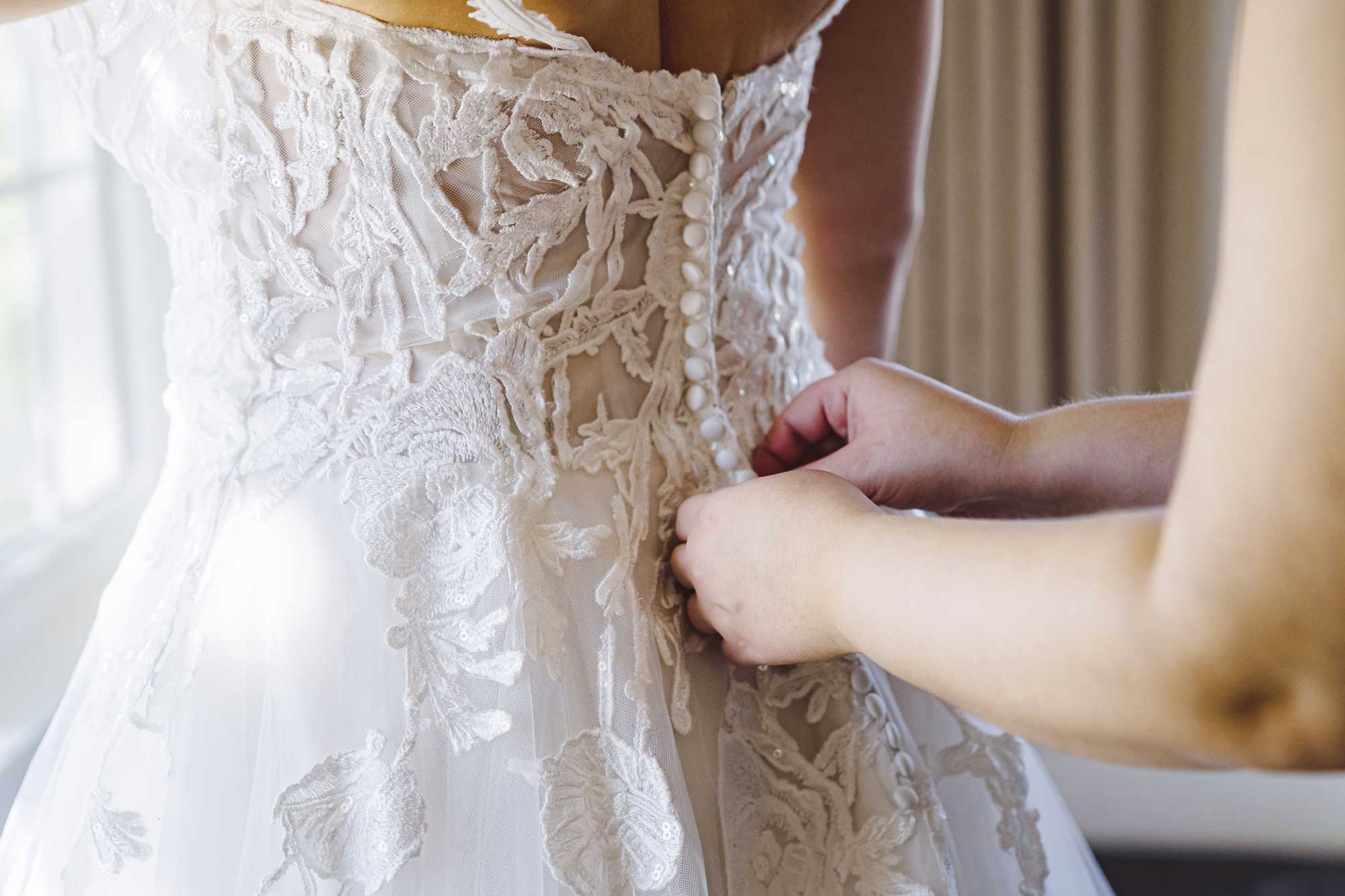 A woman is trying on wedding dresses at a bridal shop.