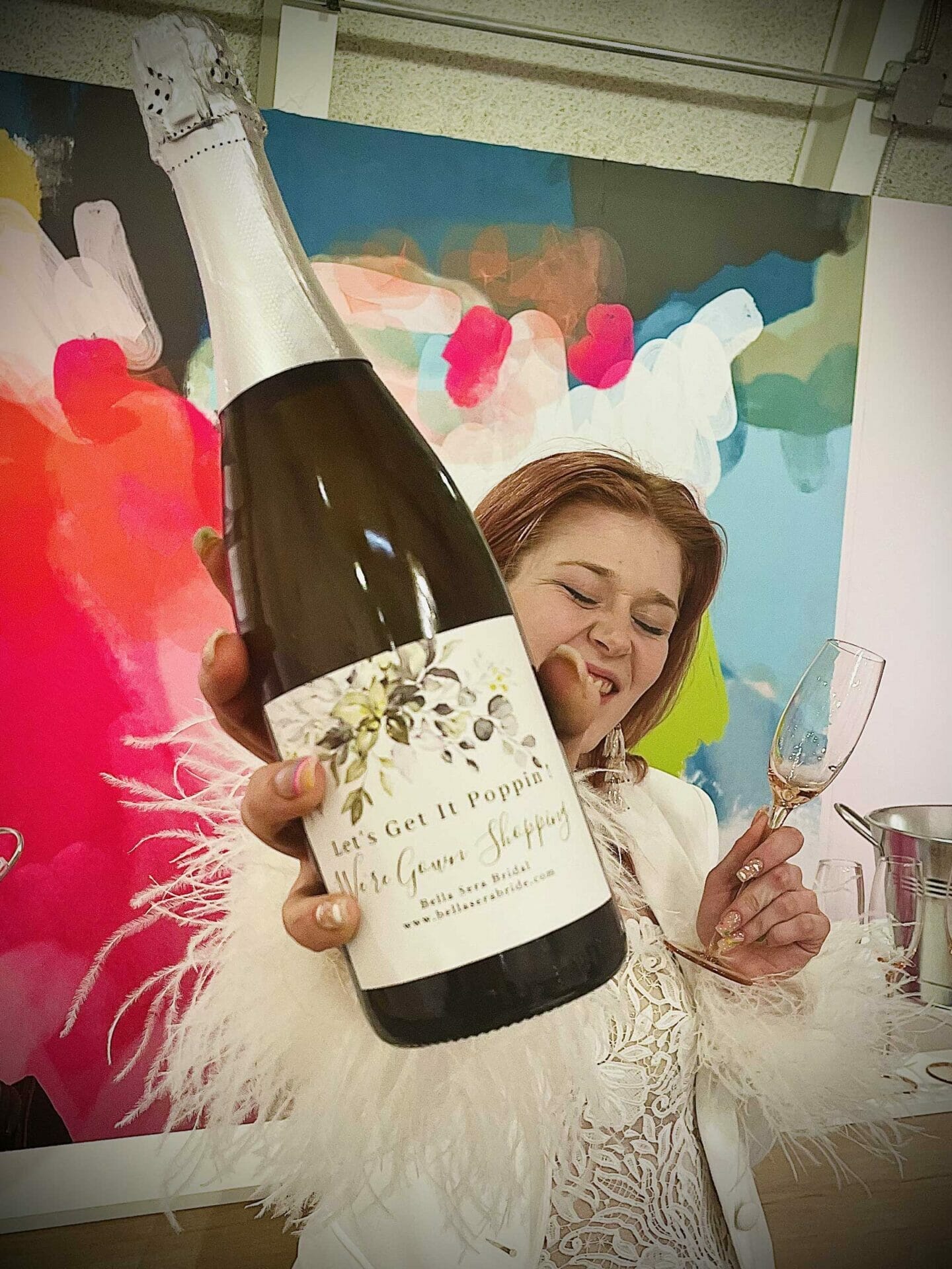 about-vibe-lounge-champagne A woman holding a bottle of champagne at a bridal salon.