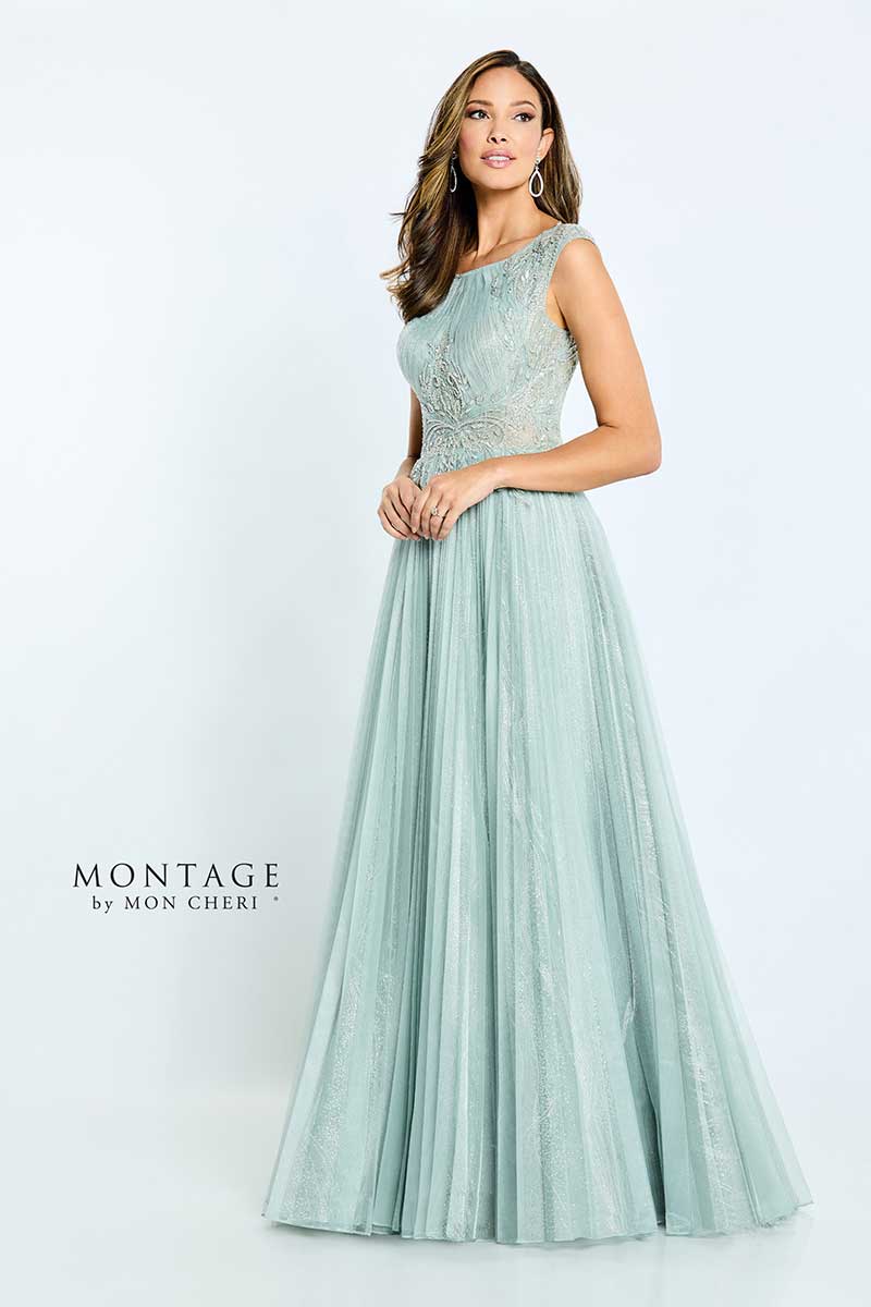 A woman in a mint green dress is posing for a photo at a bridal salon.